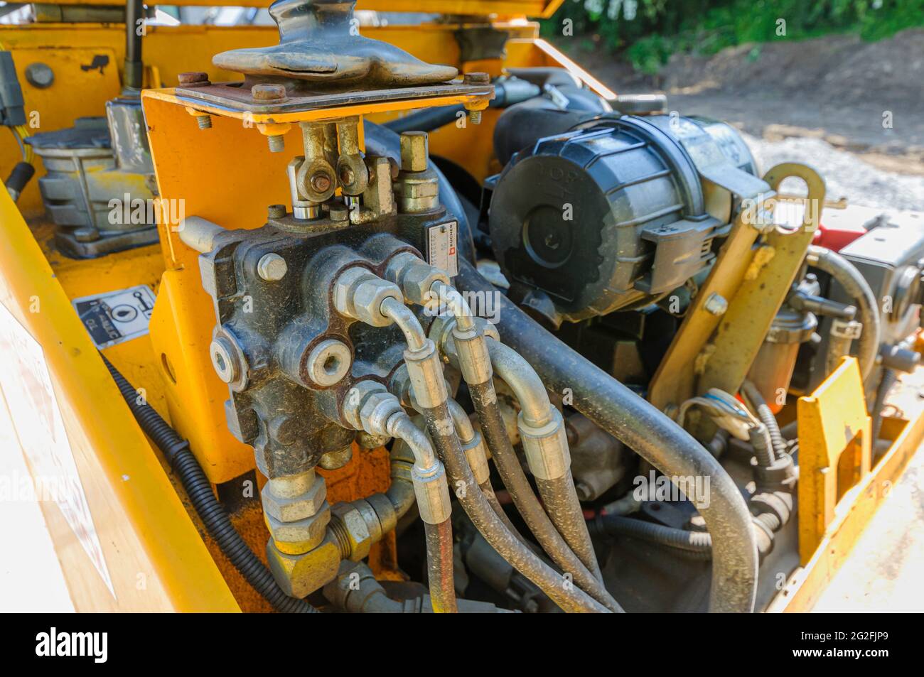 Flexibles hydrauliques et soupapes sous le siège d'un camion à benne basculante jaune. Banque D'Images