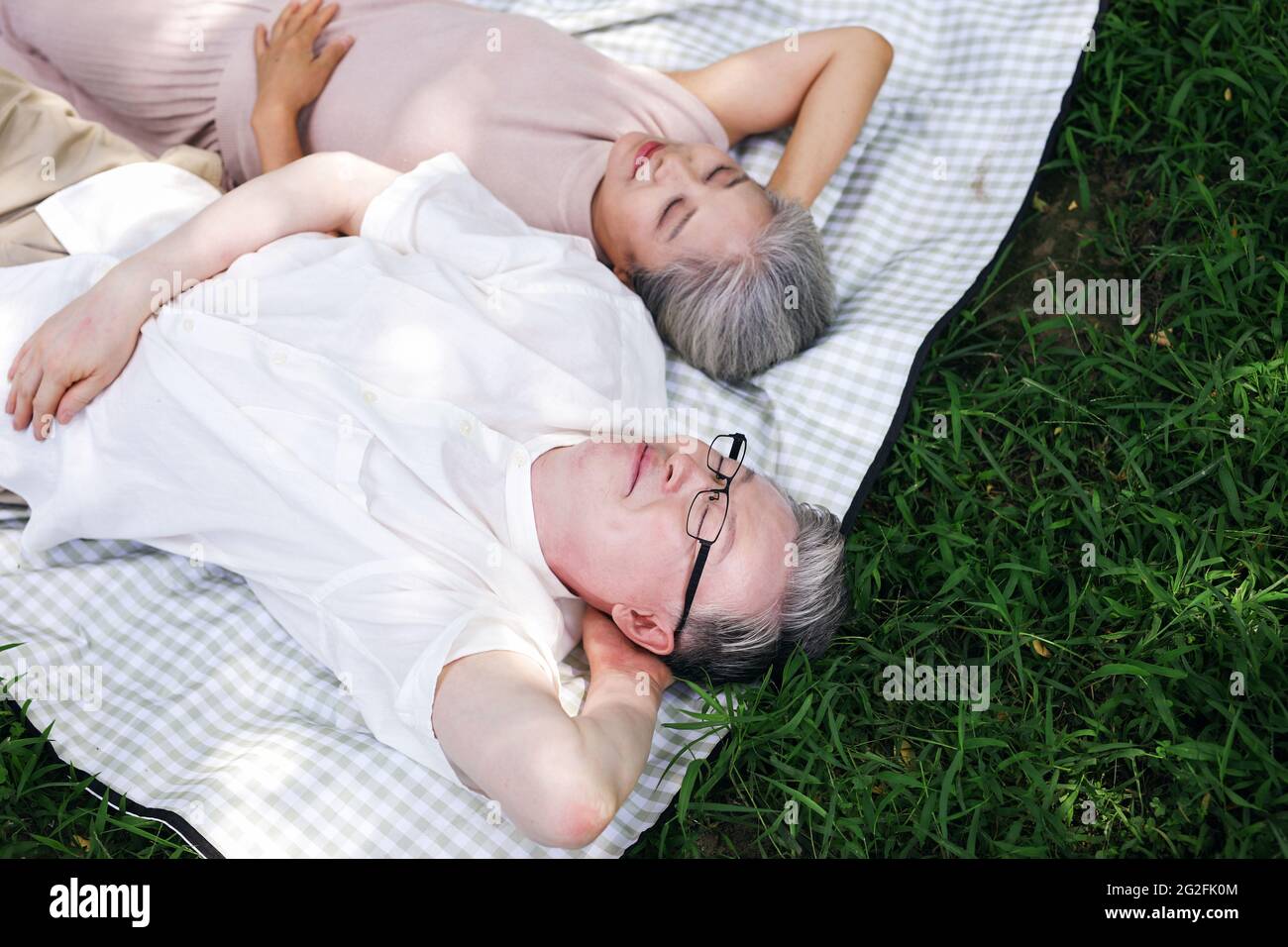 Bon vieux couple reposant sur le parc herbe photo de haute qualité Banque D'Images