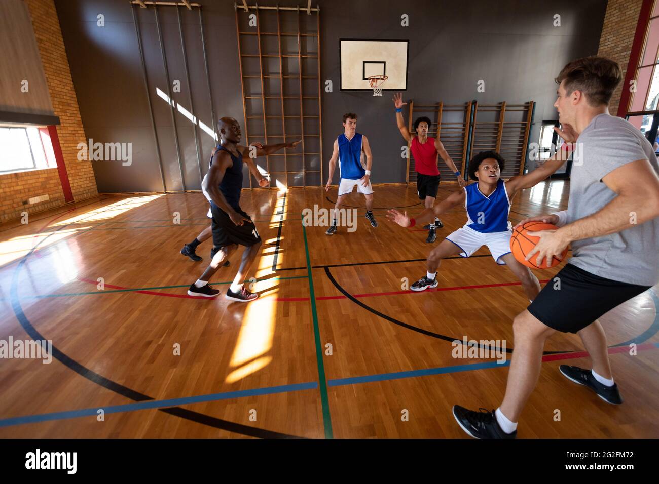 Équipe masculine de basket-ball et entraîneur divers jouant à un match Banque D'Images