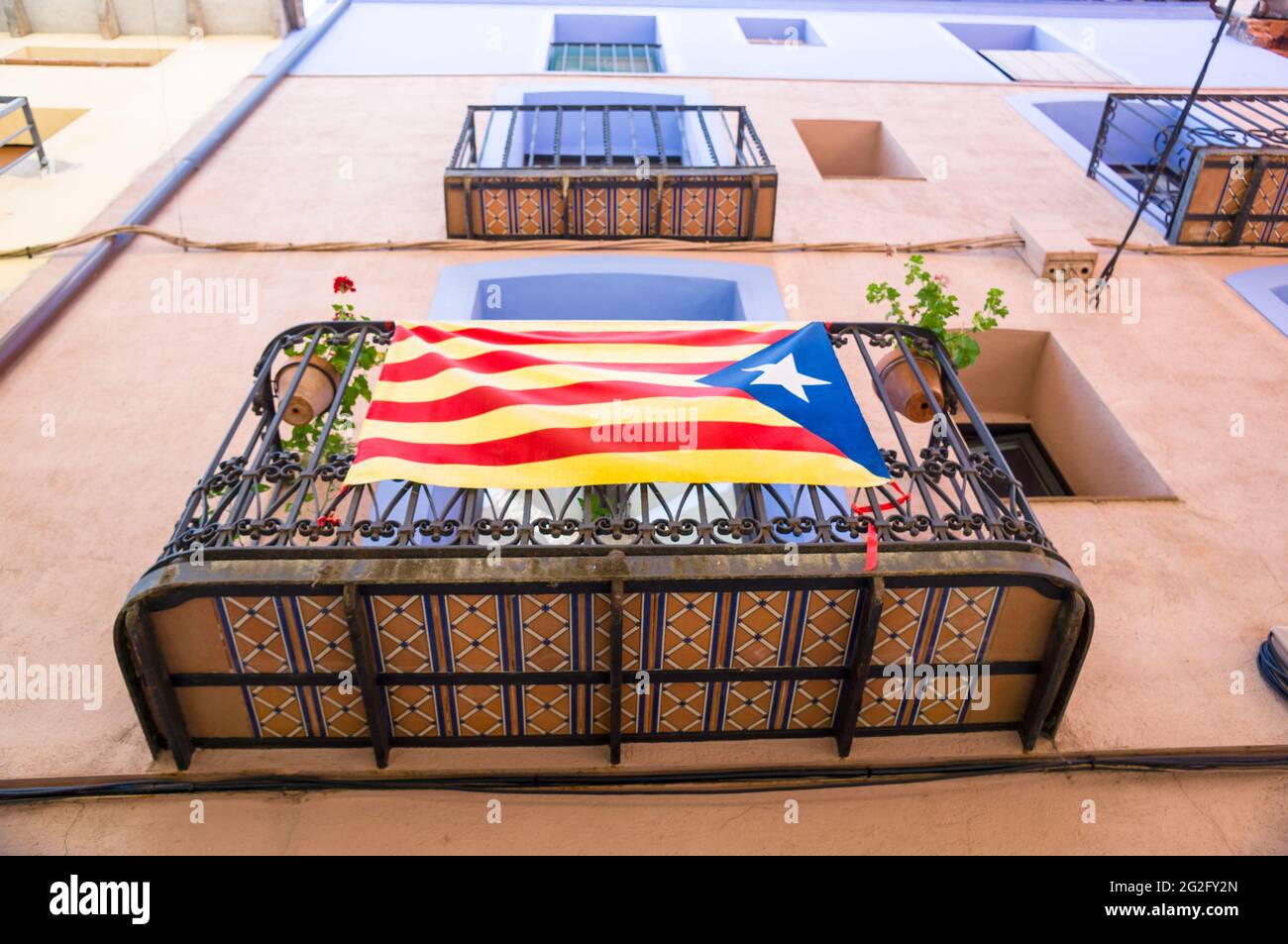 Photo à angle bas d'ESTELADA, le drapeau indépendant catalan sur un balcon de bâtiment Banque D'Images