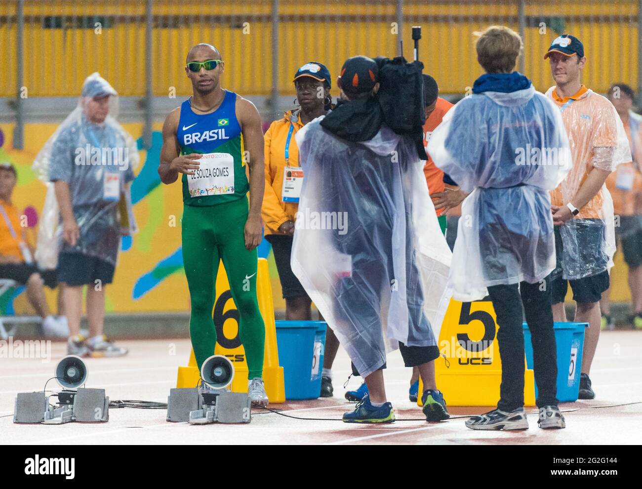 Un athlète brésilien visuellement défié sur la piste de course avec des vidéastes et des volontaires autour de lui aux Jeux Parapan américains de 2015. Le 2015 Pa Banque D'Images