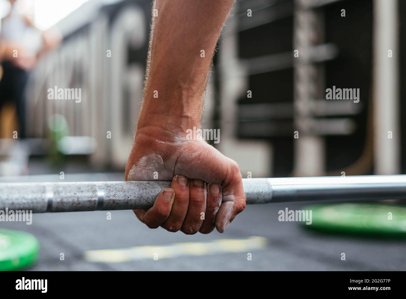 Sportif anonyme tenant une barbell dans une boîte crossfit Banque D'Images