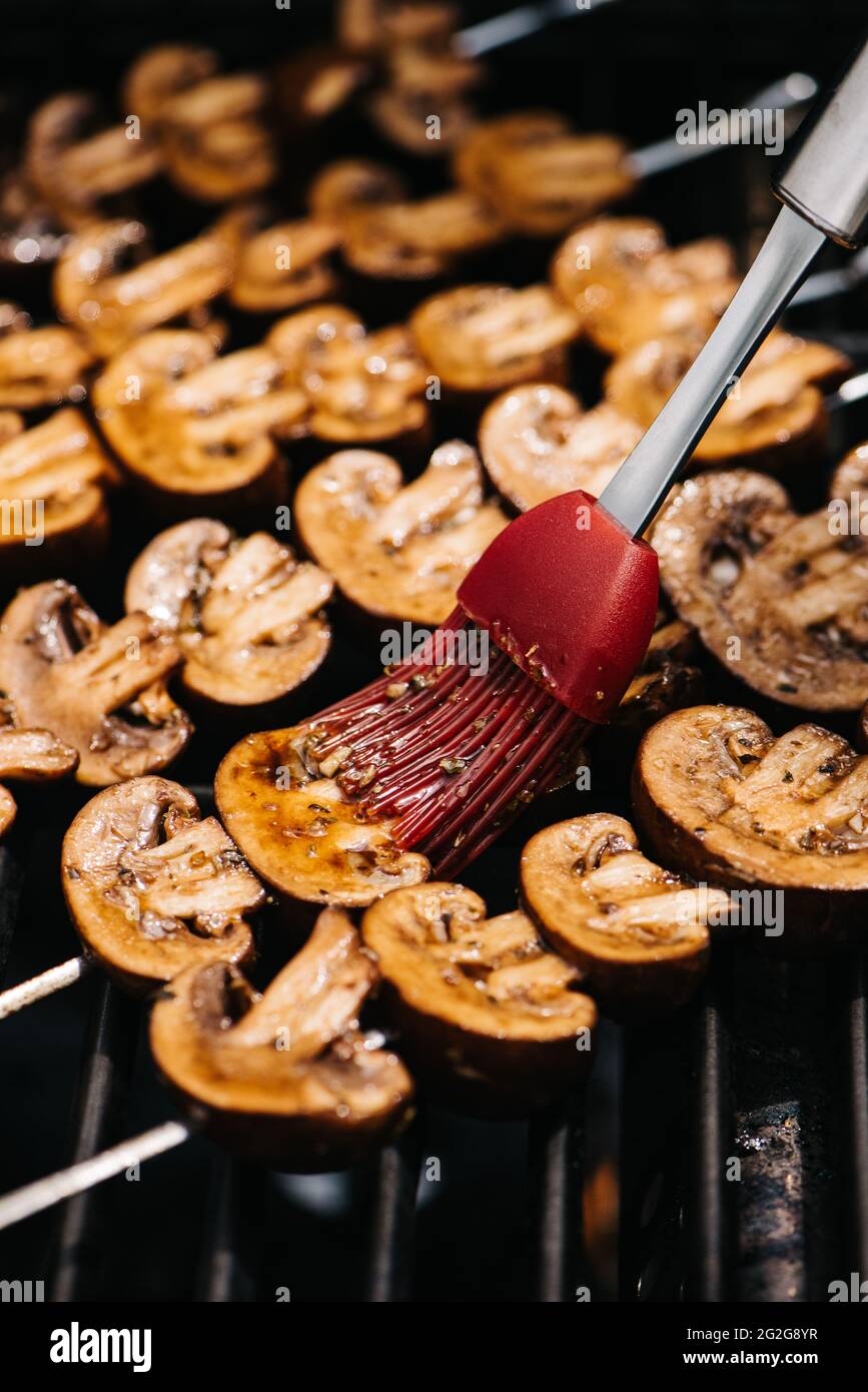 Brossez la marinade sur les brochettes de champignons Cremini Banque D'Images