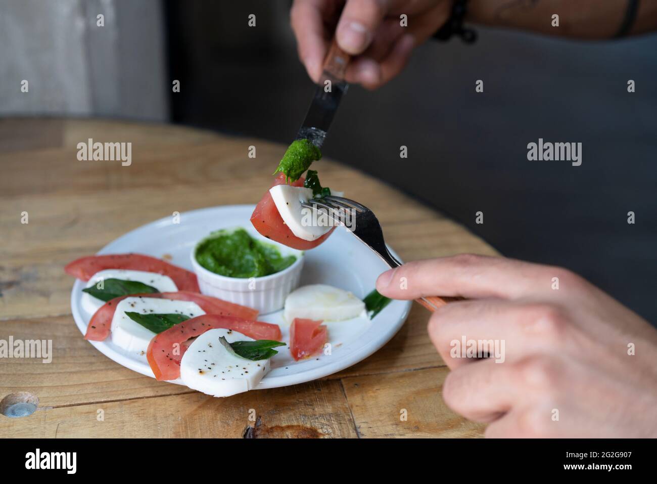 Manger de la salade Caprese avec une fourchette et un couteau Banque D'Images
