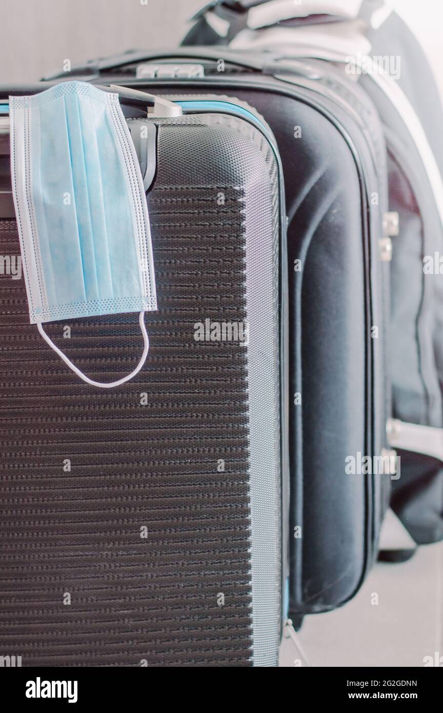 gros plan des valises noires l'une après l'autre avec un masque de protection Banque D'Images