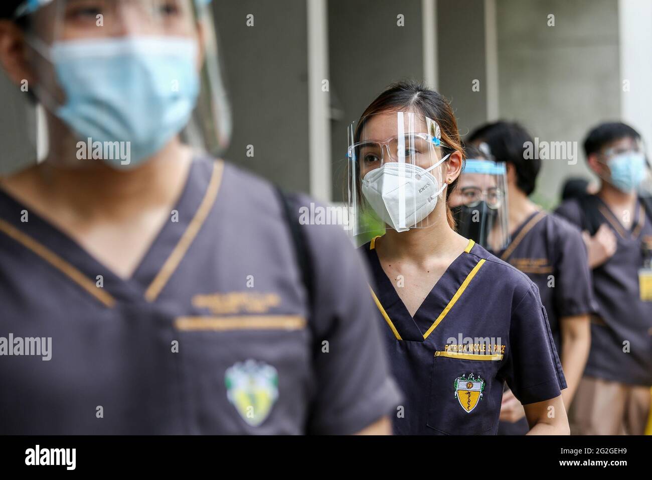 Manille, Philippines. 10 juin 2021. Les étudiants en médecine portant des masques protecteurs comme précaution contre COVID-19 font la queue lorsqu'ils entrent dans un bâtiment pour leur classe face-à-face à l'Université de Santo Tomas. L'université a commencé ses classes limitées en face à face après que le gouvernement a autorisé la reprise de la formation pratique et des cours de laboratoire dans les campus tout en observant les protocoles de santé pour prévenir la propagation de la maladie du coronavirus. Banque D'Images