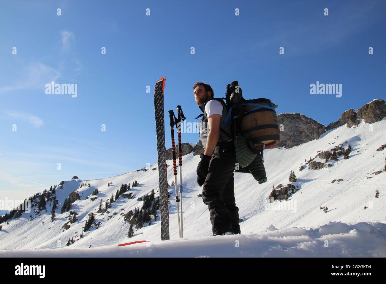 Homme avec le fût de bière Mittenwald sur son dos, skis de randonnée, équipement devant la crête du sommet du Rotwandkopf (1,858 m) Rotwand (1,884 m) dans les montagnes de Mangfall, Spitzingsee, haute-Bavière, Bavière, Allemagne, Banque D'Images