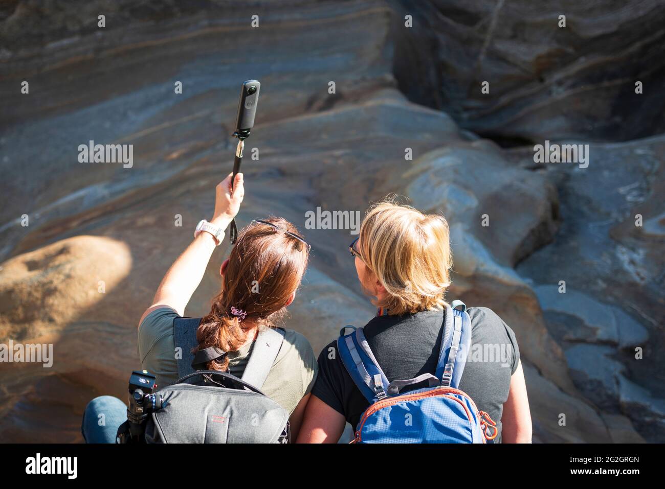 Impressions de Lastezzo dans la vallée de la Verzasca, district de Locarno, canton du Tessin en Suisse: Destination d'excursion populaire pour la randonnée, la plongée en rivière et la natation. Deux jeunes femmes prennent un selfie. Banque D'Images