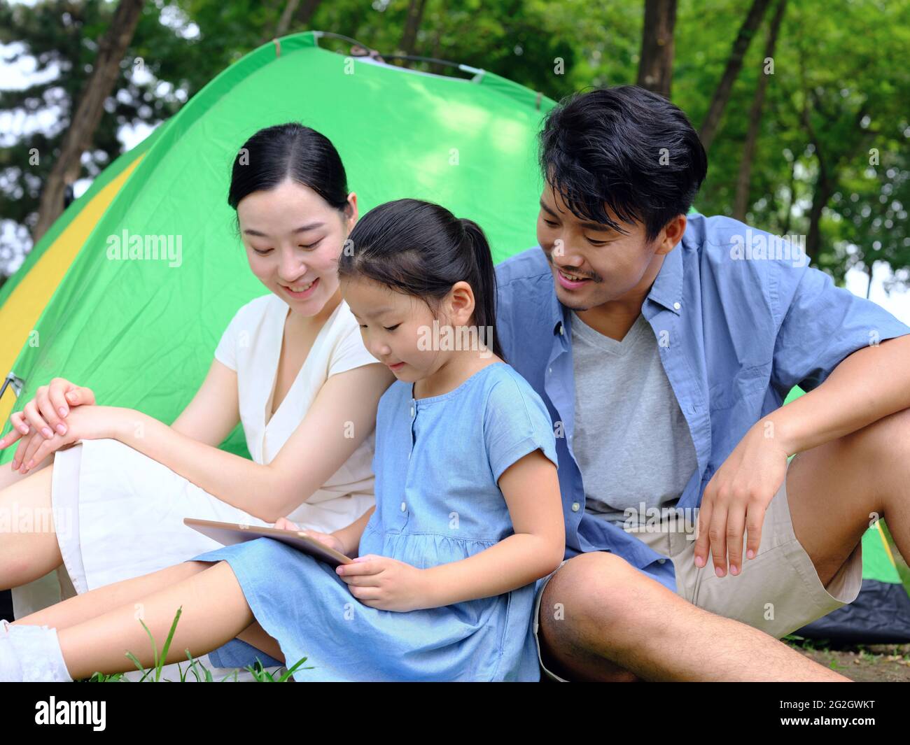 La famille heureuse de trois utilise une tablette informatique en extérieur photo de haute qualité Banque D'Images