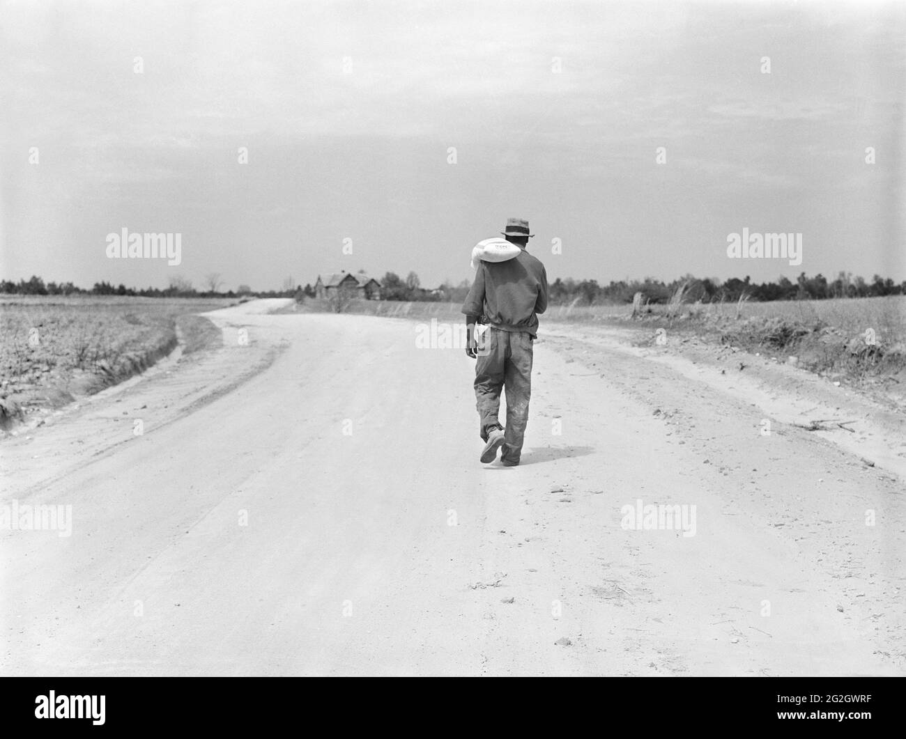 Vue arrière de tenant Farmer transportant le sac de farine, Greene County, Georgia, USA, Marion Post Wolcott, Administration américaine de la sécurité agricole, avril 1939 Banque D'Images