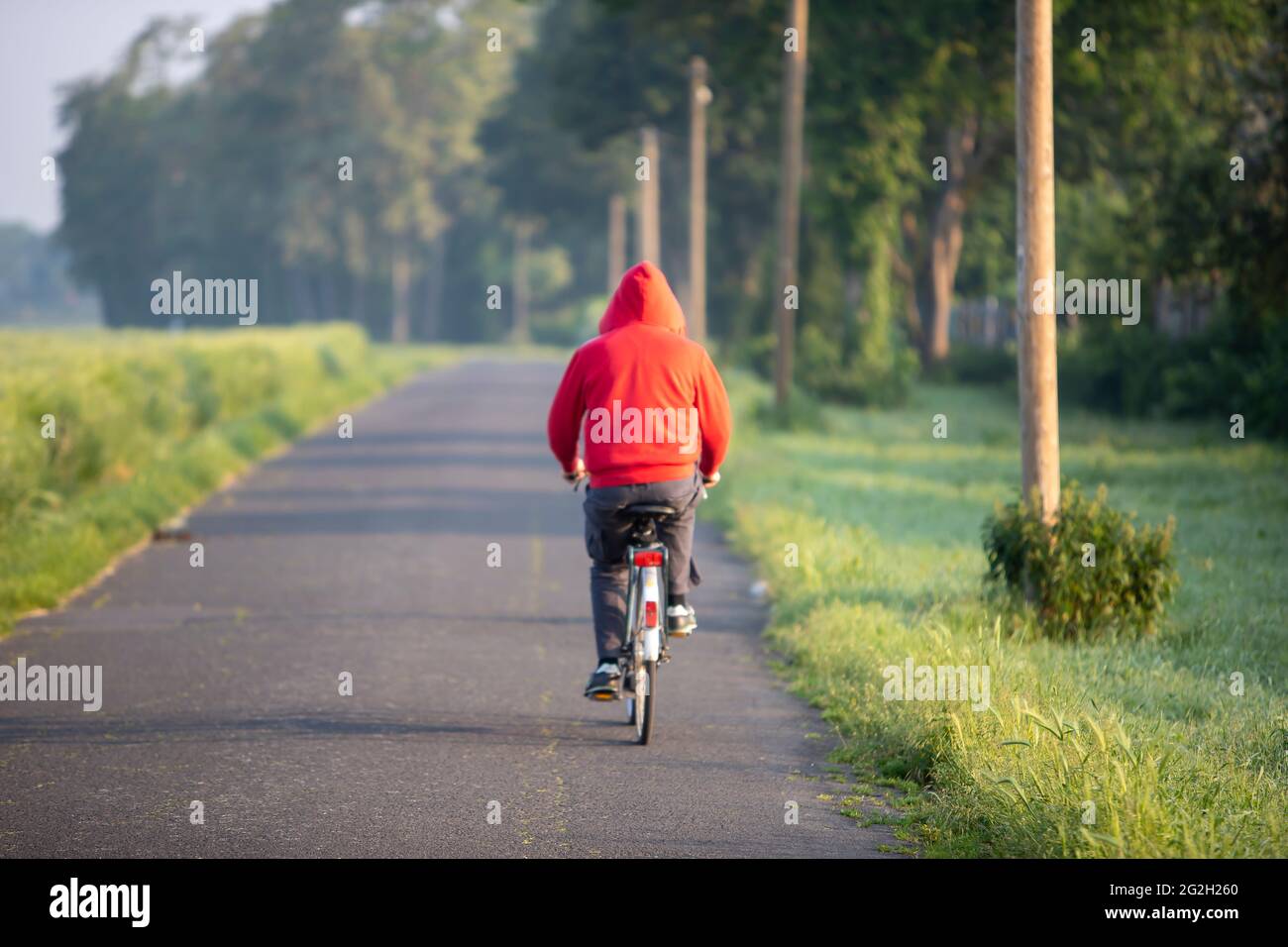 homme avec un pull à capuche rouge sur un vélo sur un sentier de campagne  Photo Stock - Alamy