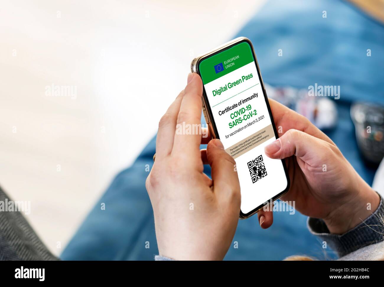 Femme tenant un smartphone avec certificat numérique Covid-19 à l'écran. Digital Green Pass permet de voyager dans l'Union européenne sans Banque D'Images