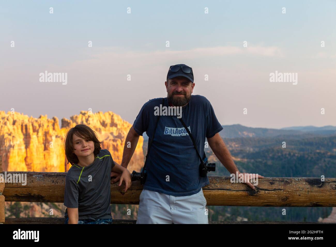 Un jeune garçon et son père appréciant le coucher du soleil depuis Swamp Canyon surplombent le parc national de Bryce Canyon, Utah, États-Unis Banque D'Images