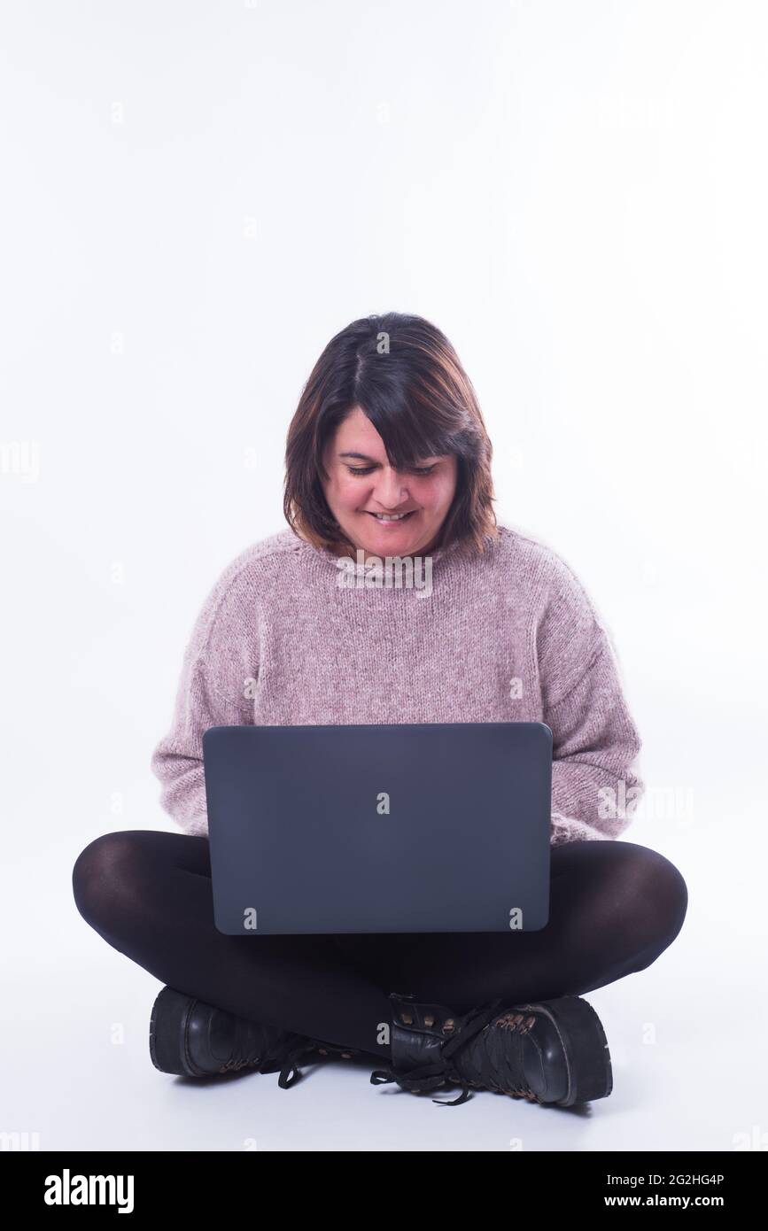 Femme assise regardant son ordinateur portable sur fond blanc. Concept d'achat en ligne. Copier Banque D'Images