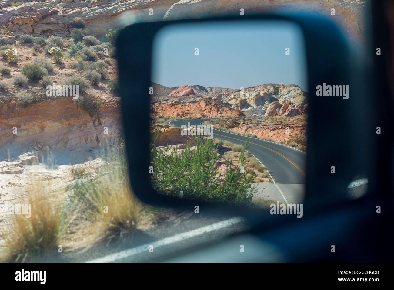 Une route sinueuse vue depuis le miroir d'une voiture dans Valley of Fire State Park, Nevada, États-Unis Banque D'Images
