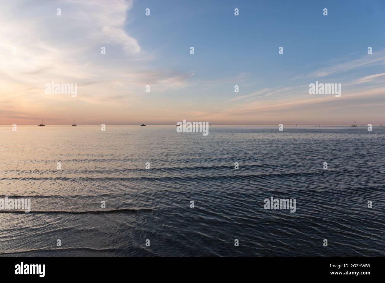 Voiliers à l'horizon sur la mer Baltique au coucher du soleil. Banque D'Images