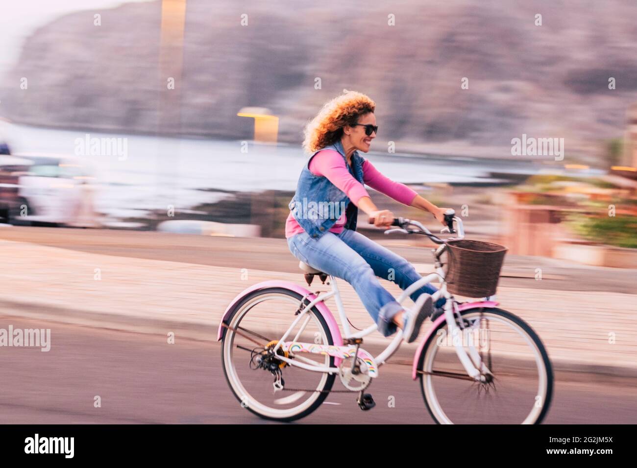 Image floue et de mouvement avec joyeuse joyeuse jeune femme appréciant la promenade à vélo et s'amuser en plein air - bonheur actif style de vie personnes concept avec femme appréciant vélo Banque D'Images