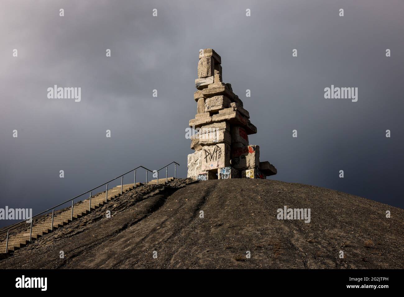 Gelsenkirchen, Rhénanie-du-Nord-Westphalie, Allemagne - Halde Rheinelbe avec l'œuvre d'art Himmelstreppe faite de vieilles parties en béton de l'ancienne mine de charbon Rheinelbe en face d'un ciel sombre, l'artiste Herman Prigann. Banque D'Images