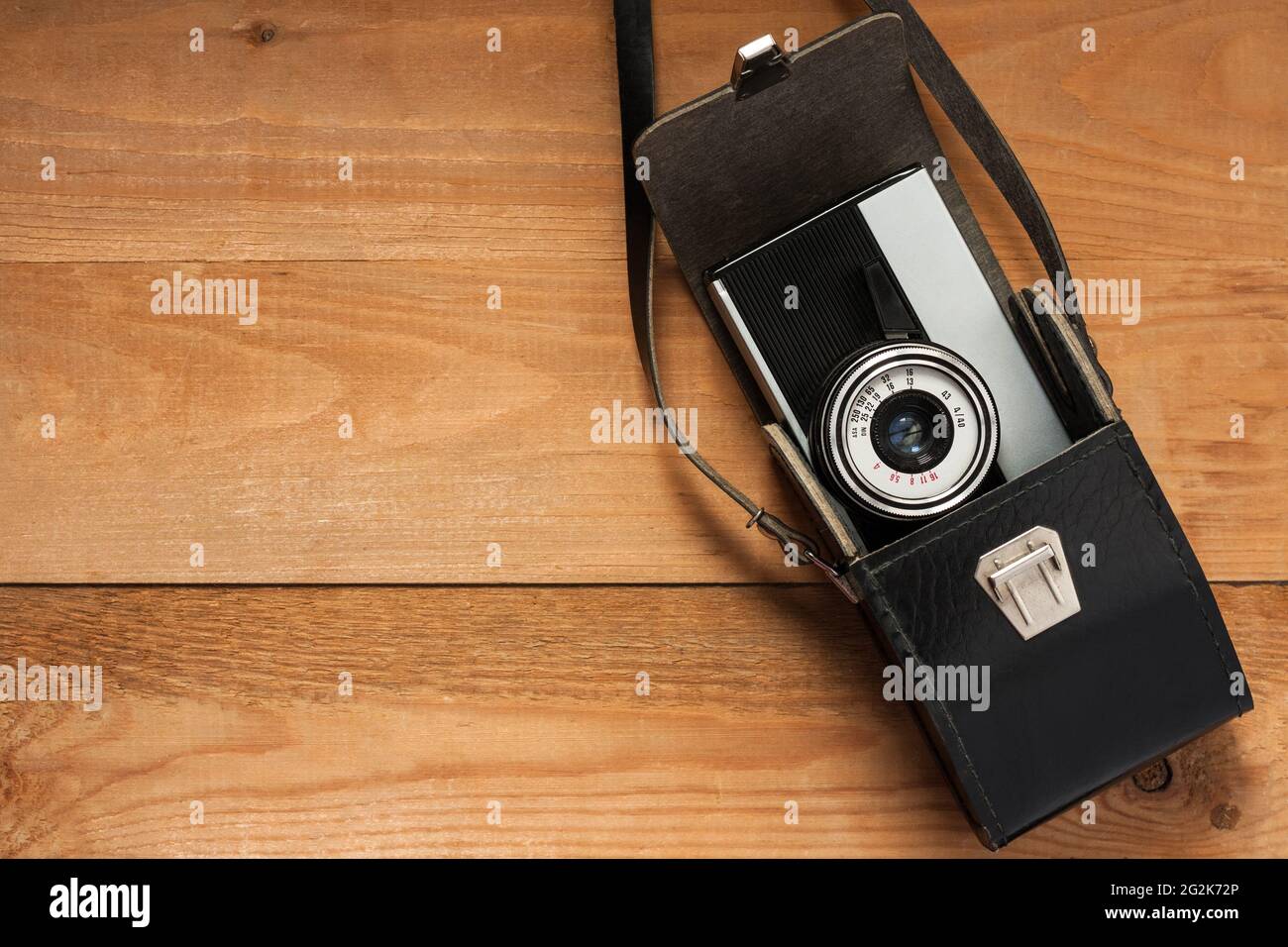 Vintage Old Retro appareil photo en cuir noir sac sur planche en bois. Vue de dessus et CopySpace. Banque D'Images