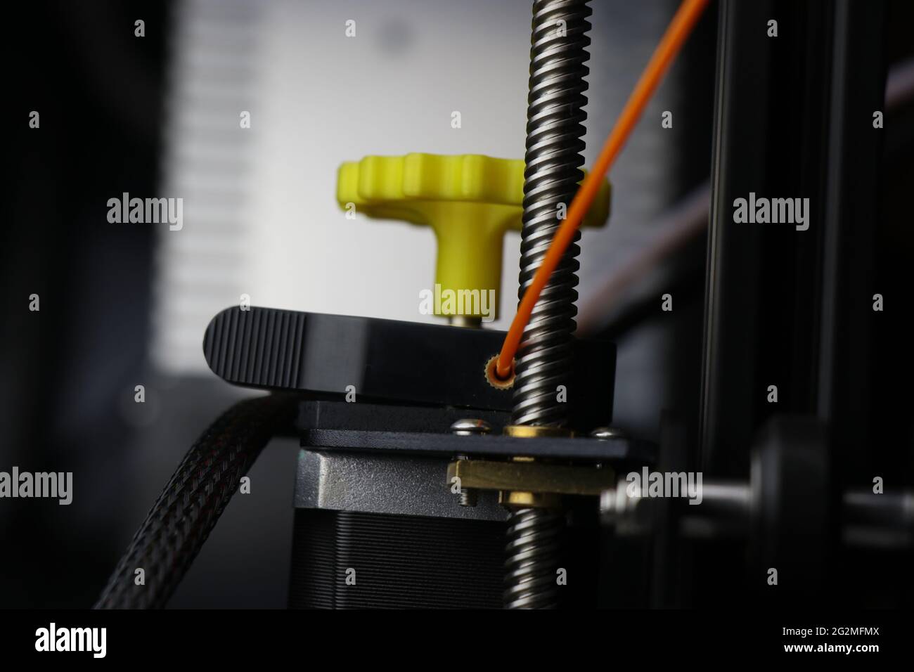 Moteur d'extrudeuse avec filament en pla de couleur orange pour la fabrication créative. Machine d'impression 3D moderne Banque D'Images