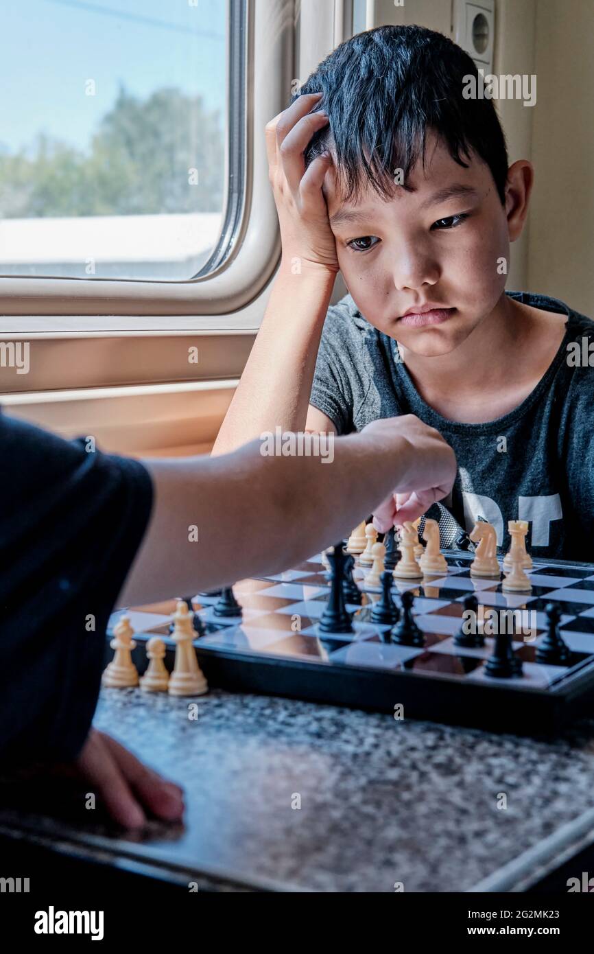 Jeunes garçons jouant aux échecs dans le train Banque D'Images