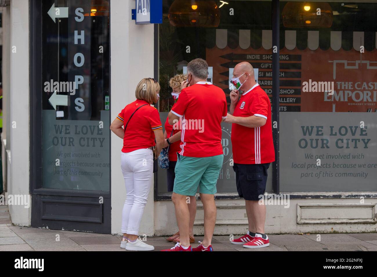 Les fans de football du pays de Galles ont mis sur le visage du drapeau gallois avant d'entrer dans un pub, le 2021 juin. Banque D'Images