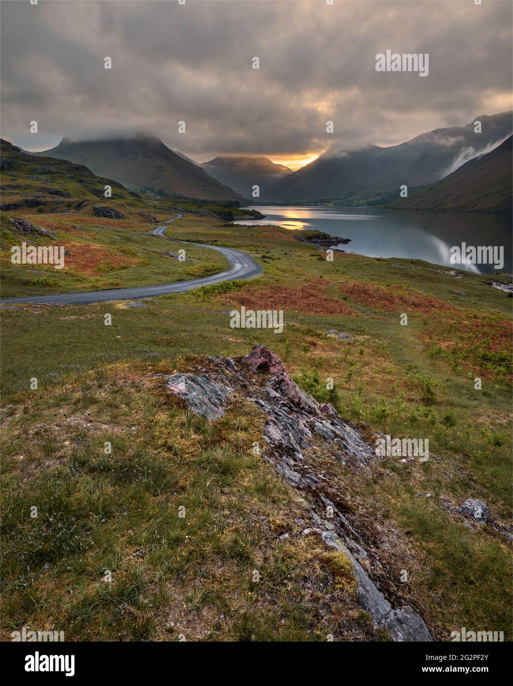 Sinueuse route à voie unique menant à travers la campagne verte isolée avec belle Sunrise. Wastwater, Lake District, Royaume-Uni. Banque D'Images