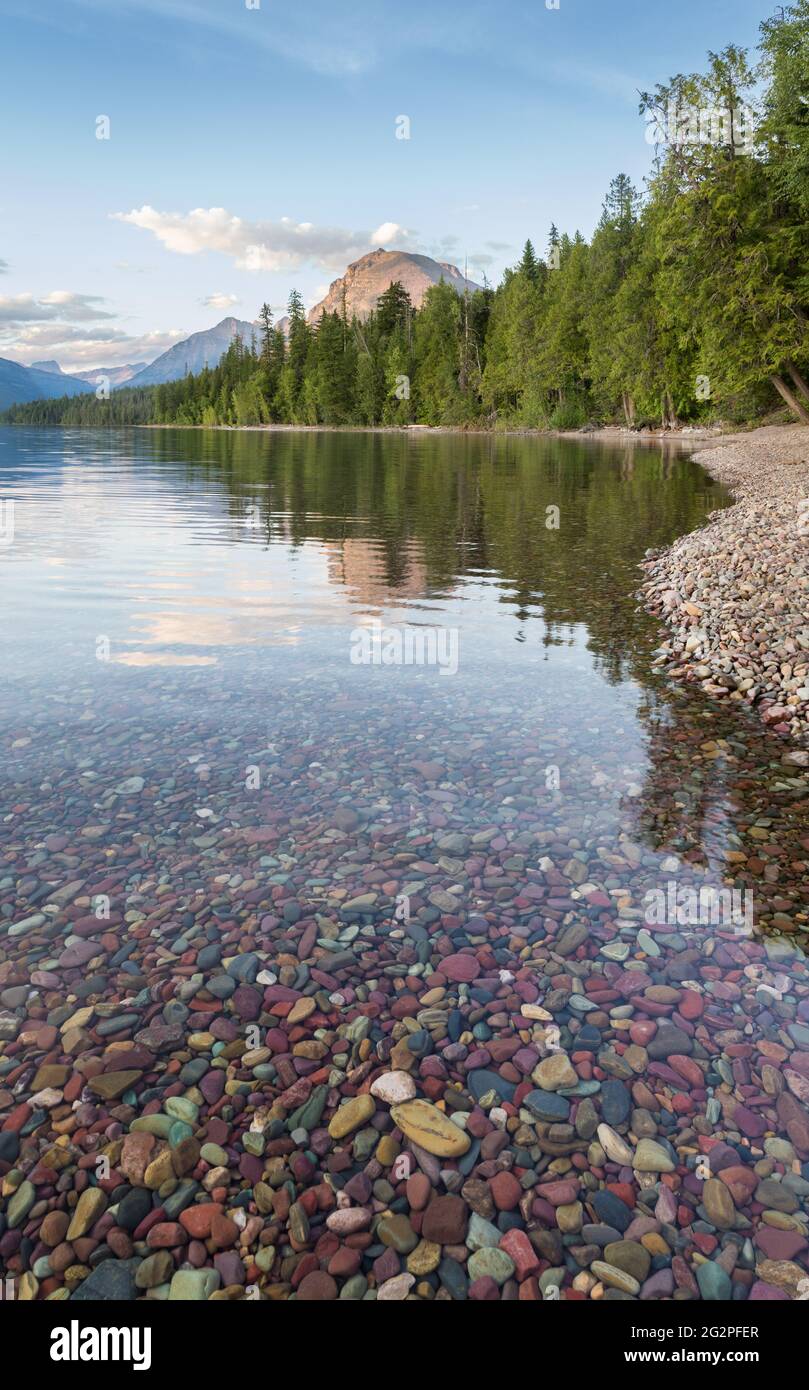Belles montagnes se reflétant dans le lac McDonald avec des galets en premier plan. Parc national des Glaciers, Montana Banque D'Images