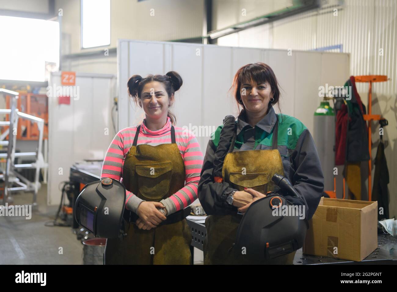 portrait de deux soudeurs tenant des masques de soudage dans leurs mains et se préparant à travailler dur dans une usine Banque D'Images