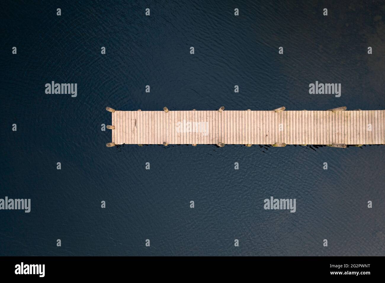 Vue d'oiseaux de la jetée en bois qui mène au-dessus du lac prise avec un drone. Banque D'Images