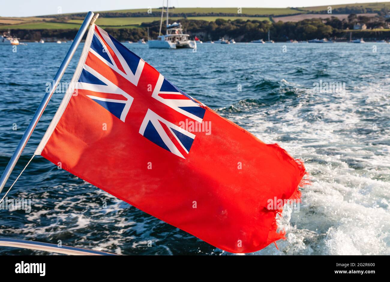 Pavillon rouge britannique volant dans le vent sur l'arc ou à l'arrière d'un bateau à voile, d'un yacht ou d'un navire Banque D'Images