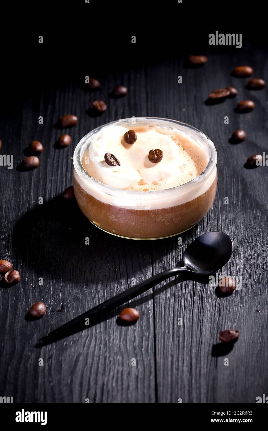 L'affogato à la vanille est recouvert de café chaud sur fond de bois noir Banque D'Images