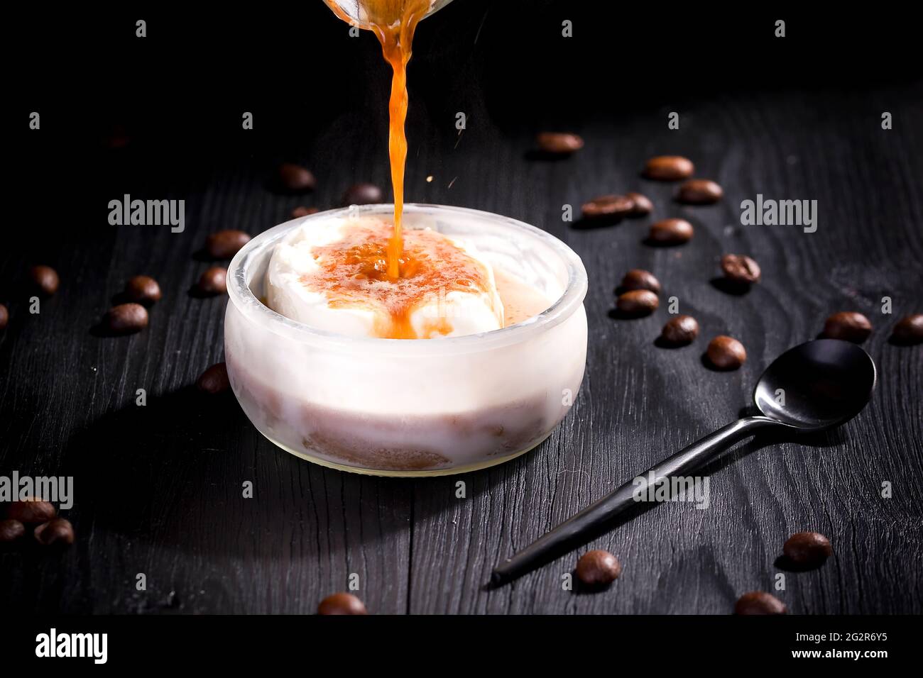 L'affogato à la vanille est recouvert de café chaud sur fond de bois noir Banque D'Images L'affogato à la vanille est recouvert de café chaud sur fond de bois noir Banque D'Images