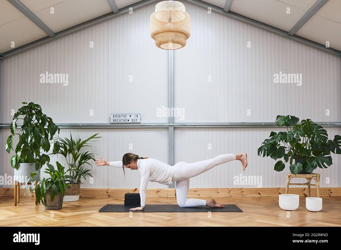 Jeune femme russe faisant des exercices complexes et le yoga stretching dans une belle salle de gym, bien décorée Banque D'Images