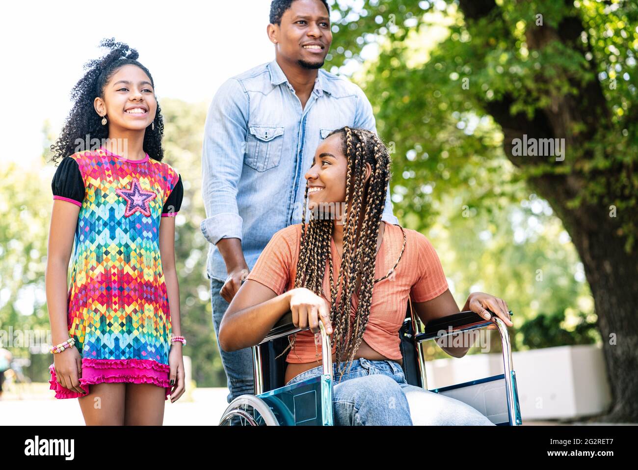 Femme en fauteuil roulant en train de faire une promenade en famille. Banque D'Images