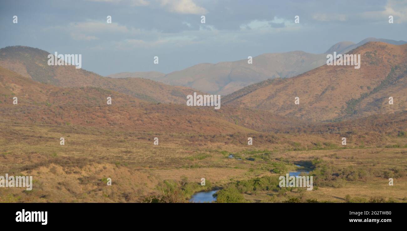 Vue panoramique sur la nature sauvage sur le South African highveld près de Barberton/Elukwatini avec le Royaume de montagne d'eSwatini en arrière-plan avec une rivière Banque D'Images
