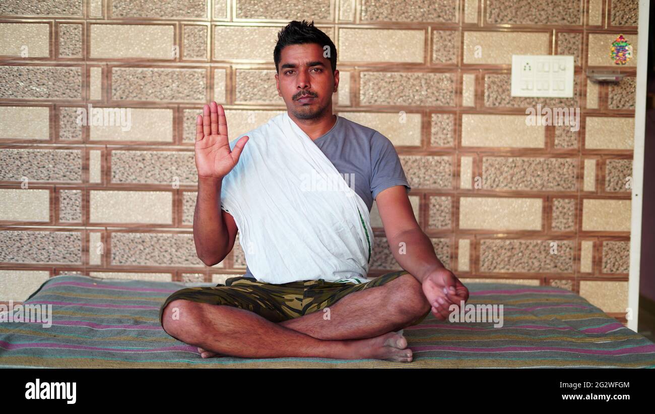 Jeune homme asiatique assis en position Yoga et méditant à la maison. Concept de journée mondiale de yoga. Banque D'Images