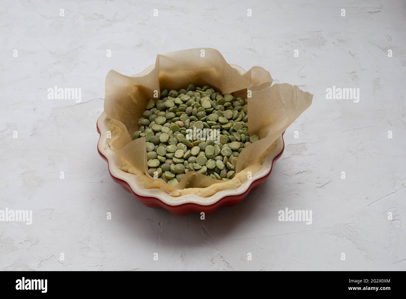 Pâte à tartelette à pâtisserie aveugle avec lentilles vertes en deux parties sous forme de mini tarte rouge Banque D'Images