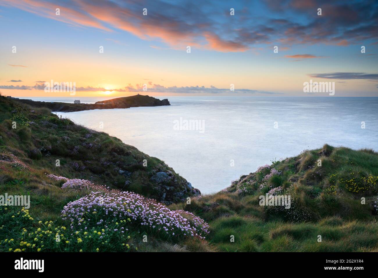 Towan Head près de Newquay, sur la côte nord de Cornwall. L'image a été prise au coucher du soleil au printemps en utilisant une longue exposition pour rendre l'eau floue. Banque D'Images