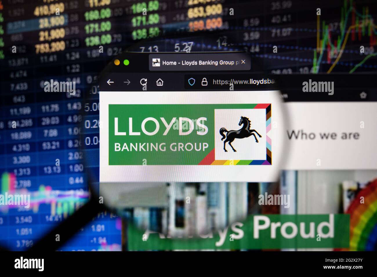 Logo de la société du groupe bancaire Lloyds sur un site Web présentant des développements flous du marché boursier en arrière-plan, vu sur un écran d'ordinateur Banque D'Images