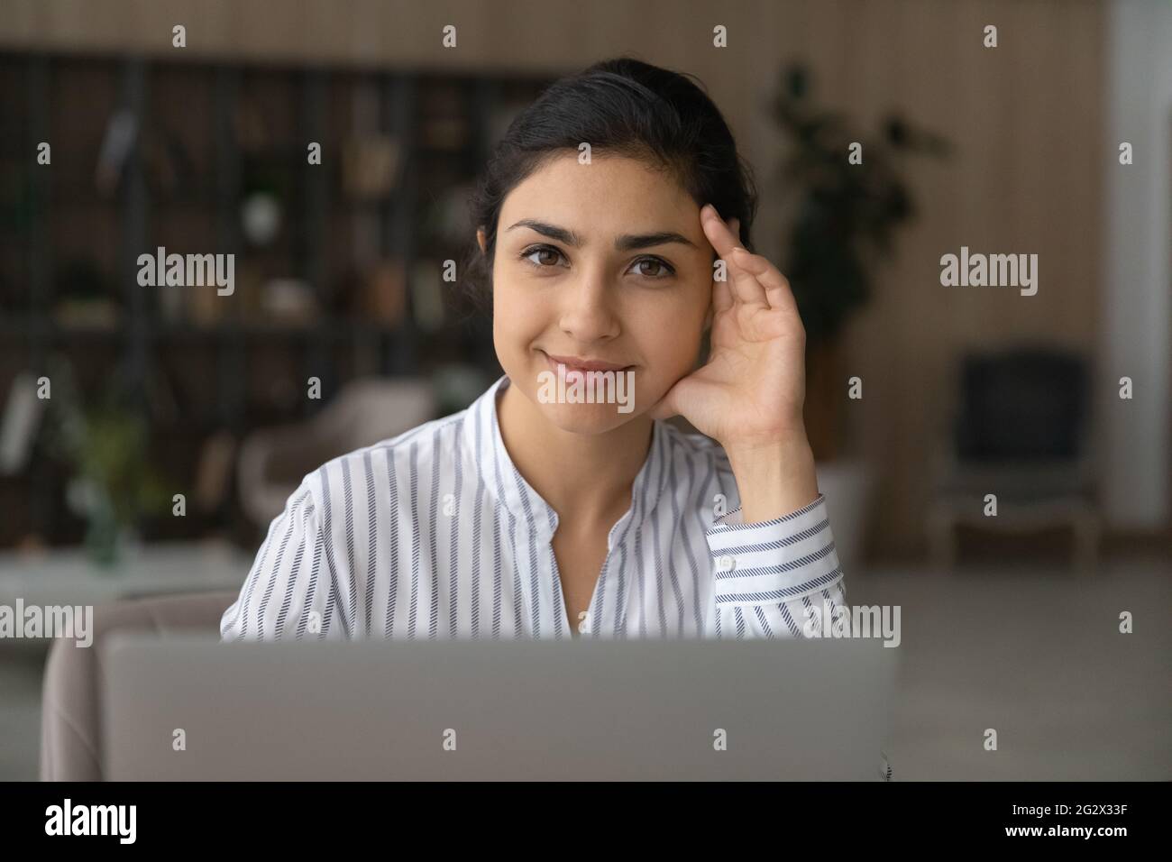 Portrait d'une jeune femme indienne motivée par un écran d'ordinateur portable Banque D'Images