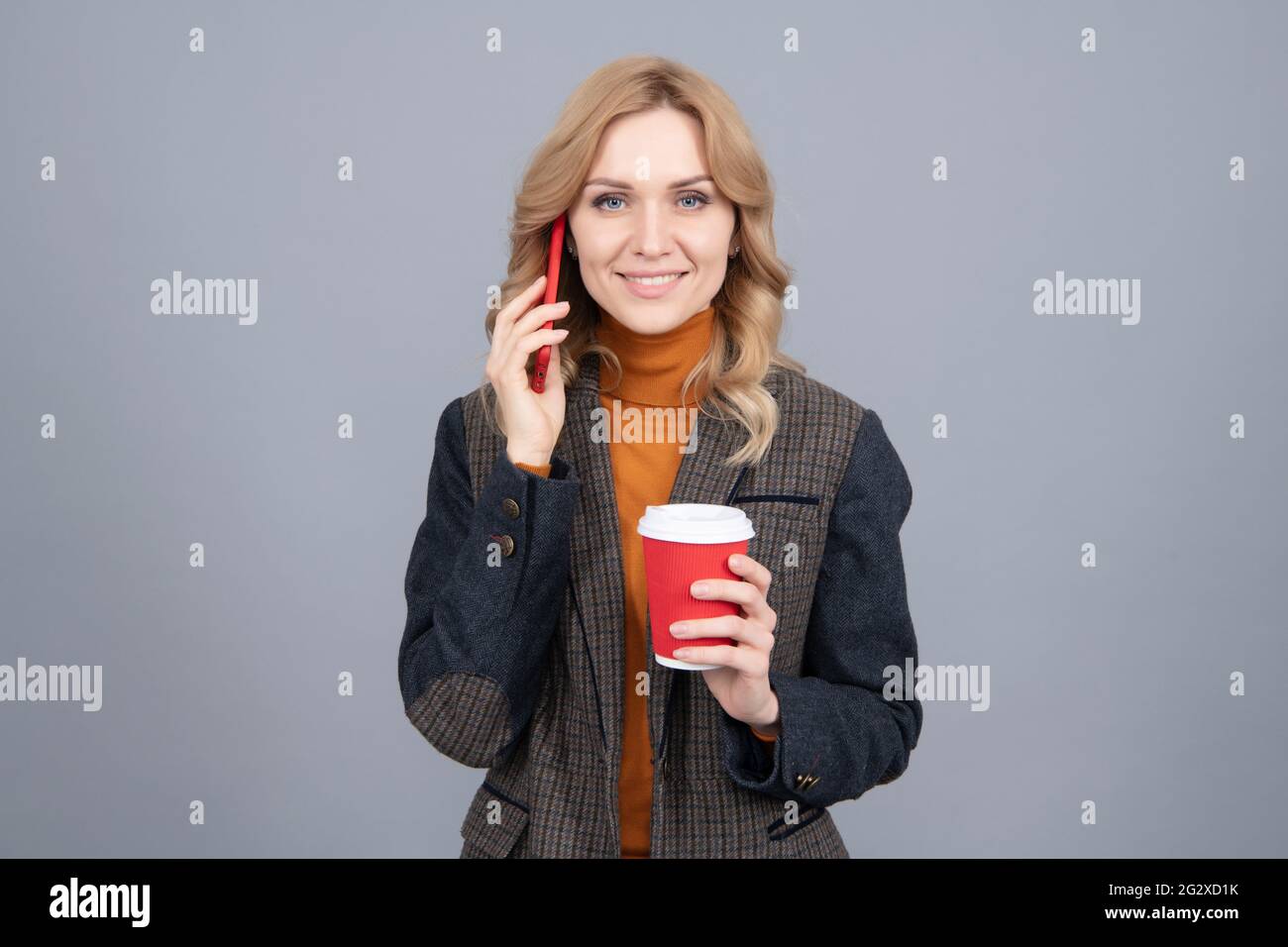 Une femme parle au téléphone en train de boire du café. Caféine et addiction au smartphone. Dépendance à la technologie Banque D'Images