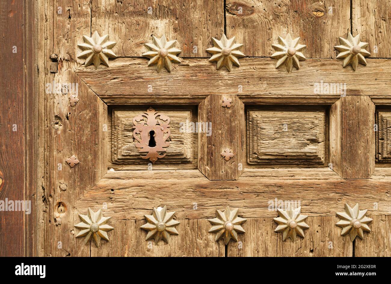 Ancienne porte en bois avec beaucoup de texture et avec clous forgés et verrou en fer. Banque D'Images