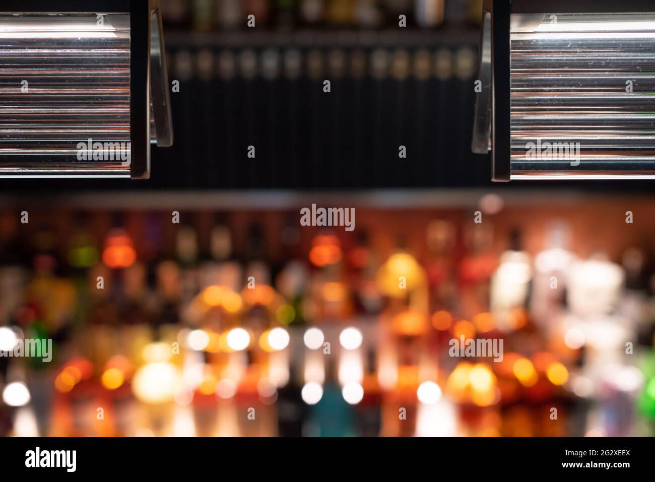 Compteur à barres défoqué avec flacons rétroéclairés en arrière-plan la nuit Banque D'Images