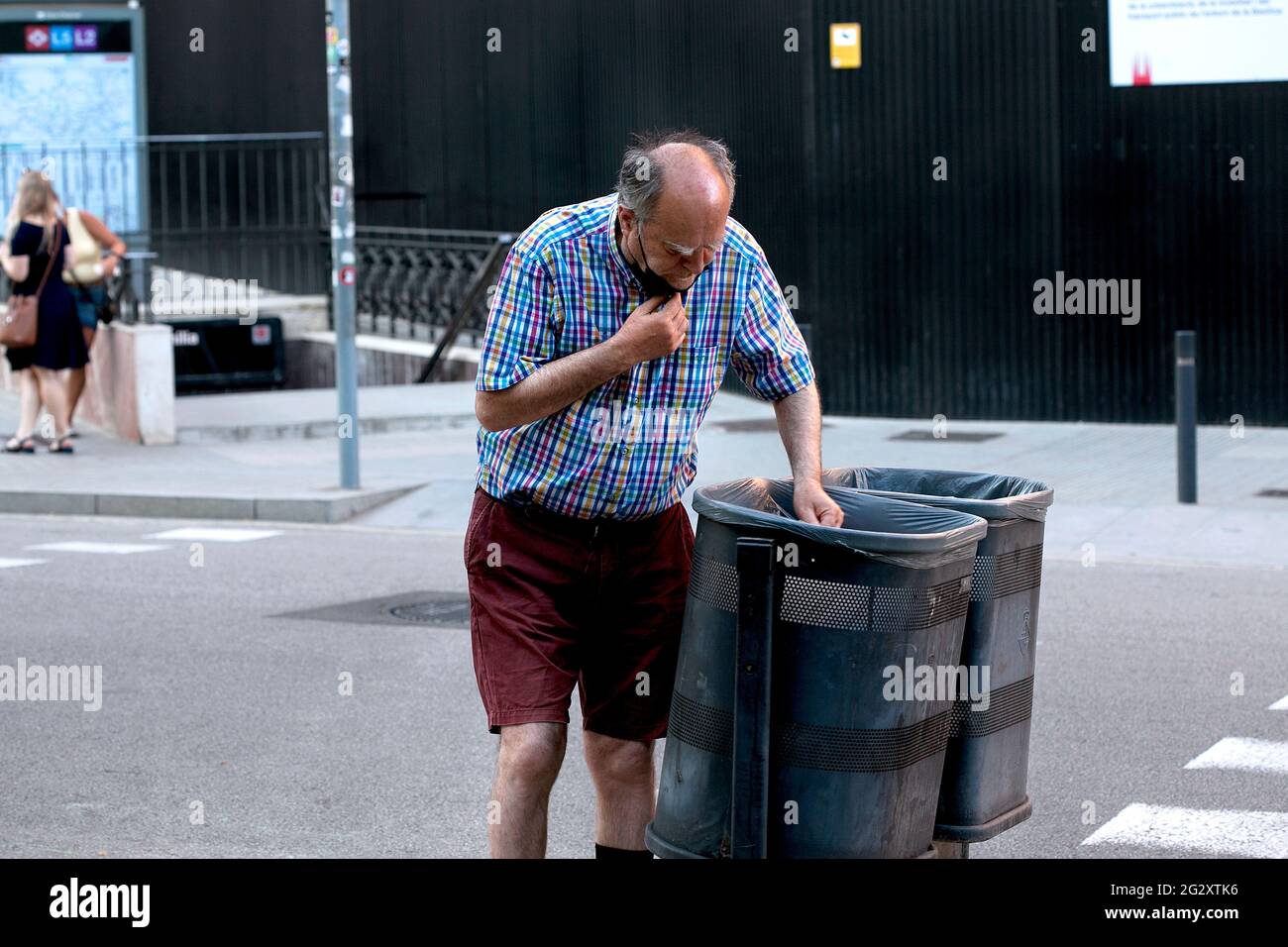 Homme traversant les poubelles, Barcelone, Espagne. Banque D'Images