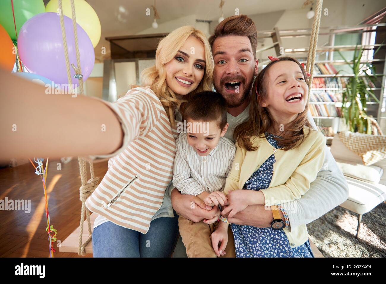 Les enfants et les parents passent un bon moment tout en prenant un selfie dans une atmosphère gaie à la maison ensemble. Famille, loisirs, ensemble Banque D'Images