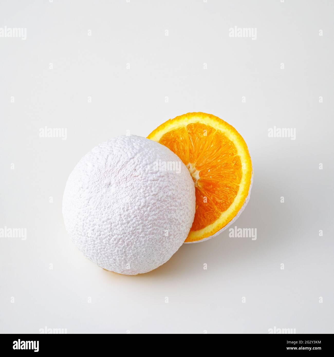 Idée surréaliste d'un fruit orange blanc découpé sur fond blanc. Banque D'Images