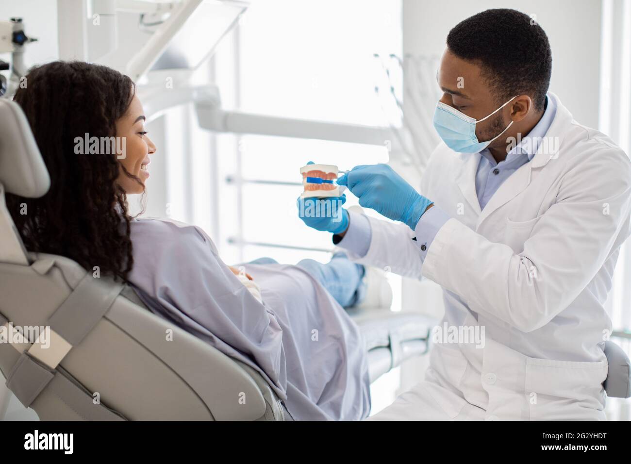 Hygiène dentaire. Dentiste tenant le modèle de mâchoire et montrant comment brosser les dents Banque D'Images