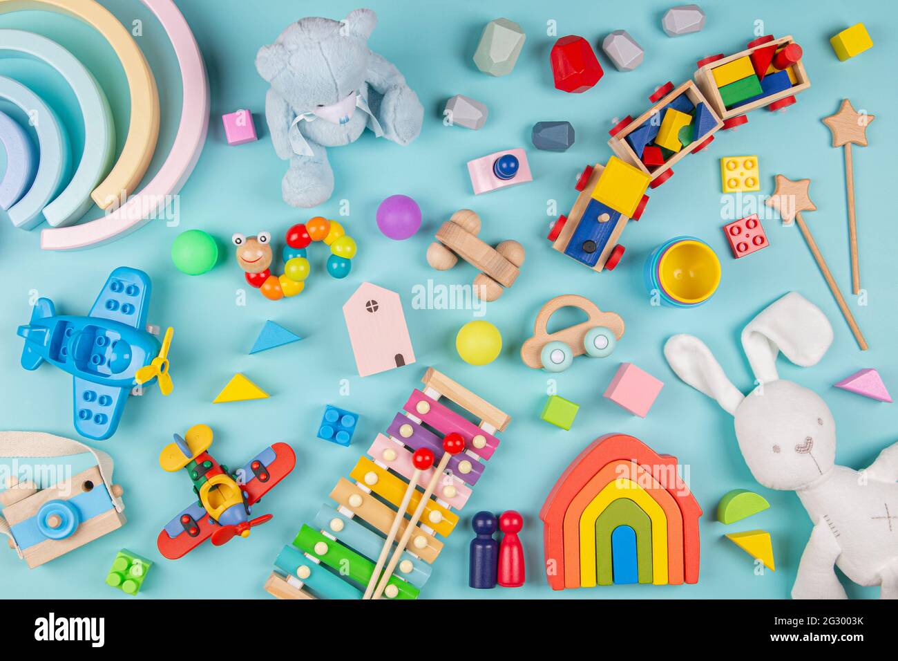 Motif de jouets pour bébés enfants. Ensemble de jouets éducatifs en bois et molletonnés colorés sur fond bleu. Vue de dessus, plan d'appartement Banque D'Images