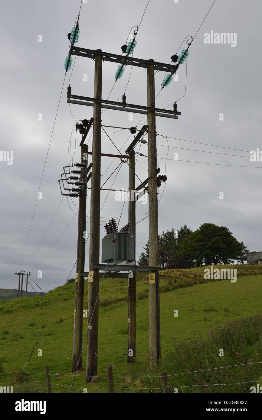 Pylône électrique en bois avec un transformateur sur poteau (PMT) et une jonction, à l'île de Kerrera, en Grande-Bretagne. Banque D'Images